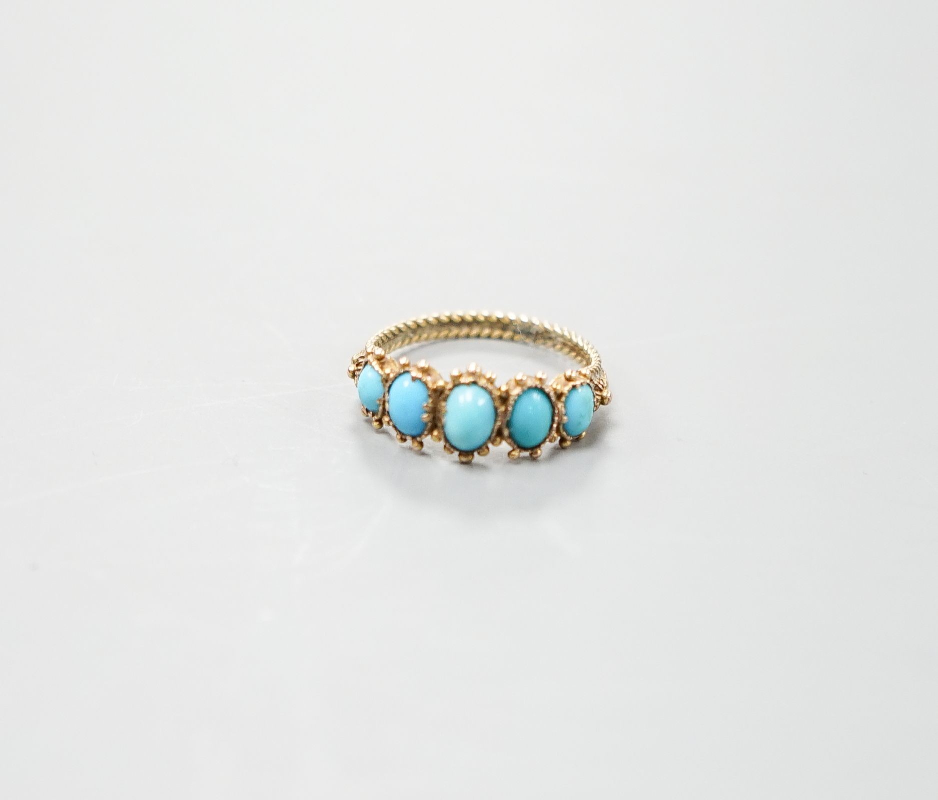 An early 19th century yellow metal and graduated five stone cabochon turquoise half hoop ring, size N, gross weight 1.9 grams.